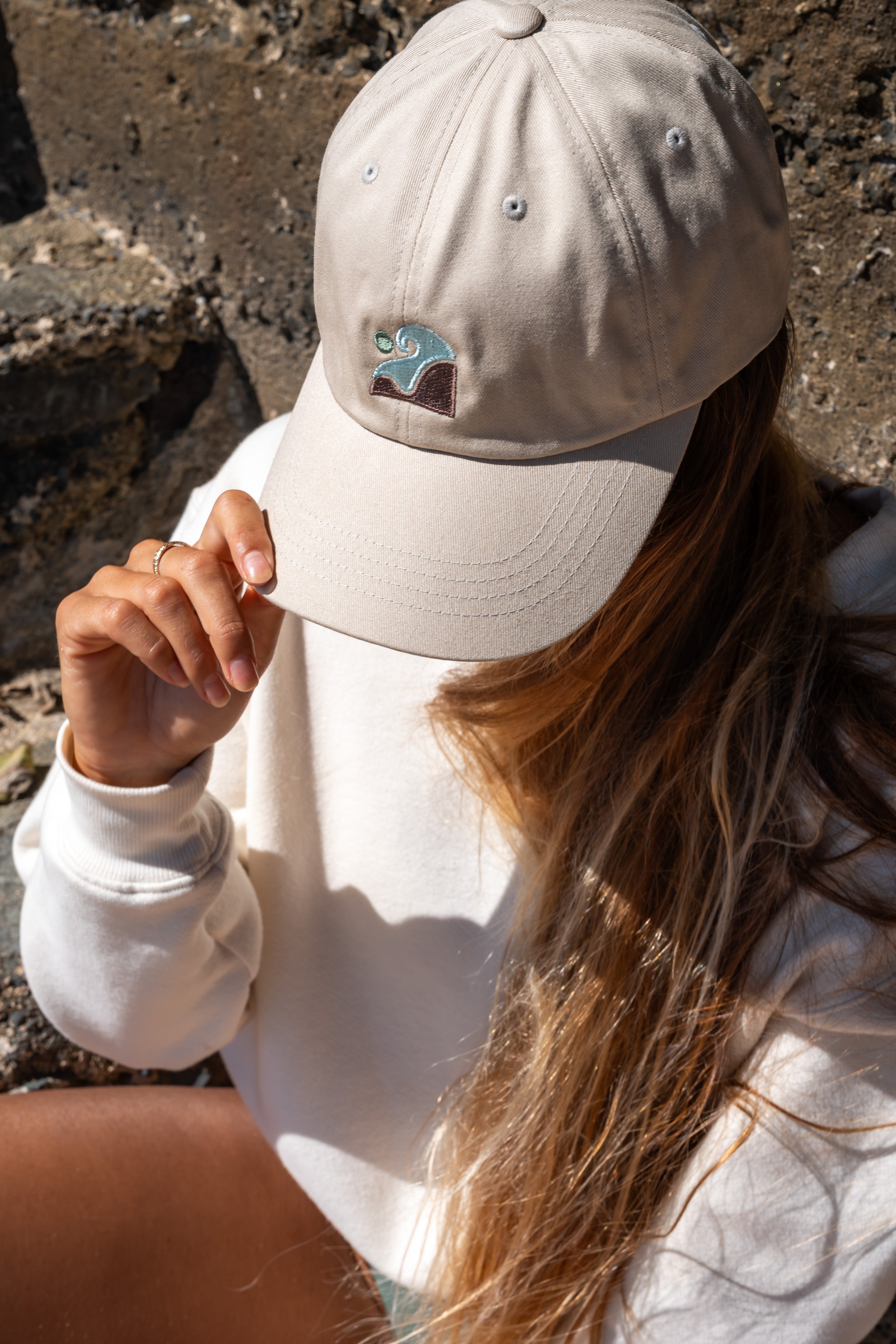 Beige cotton twill CRC hat with embroidered Coastal Range Collective logo, worn by a person.