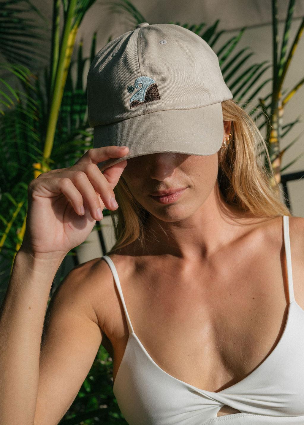 Girl with earrings wears baseball cap and white bikini top
