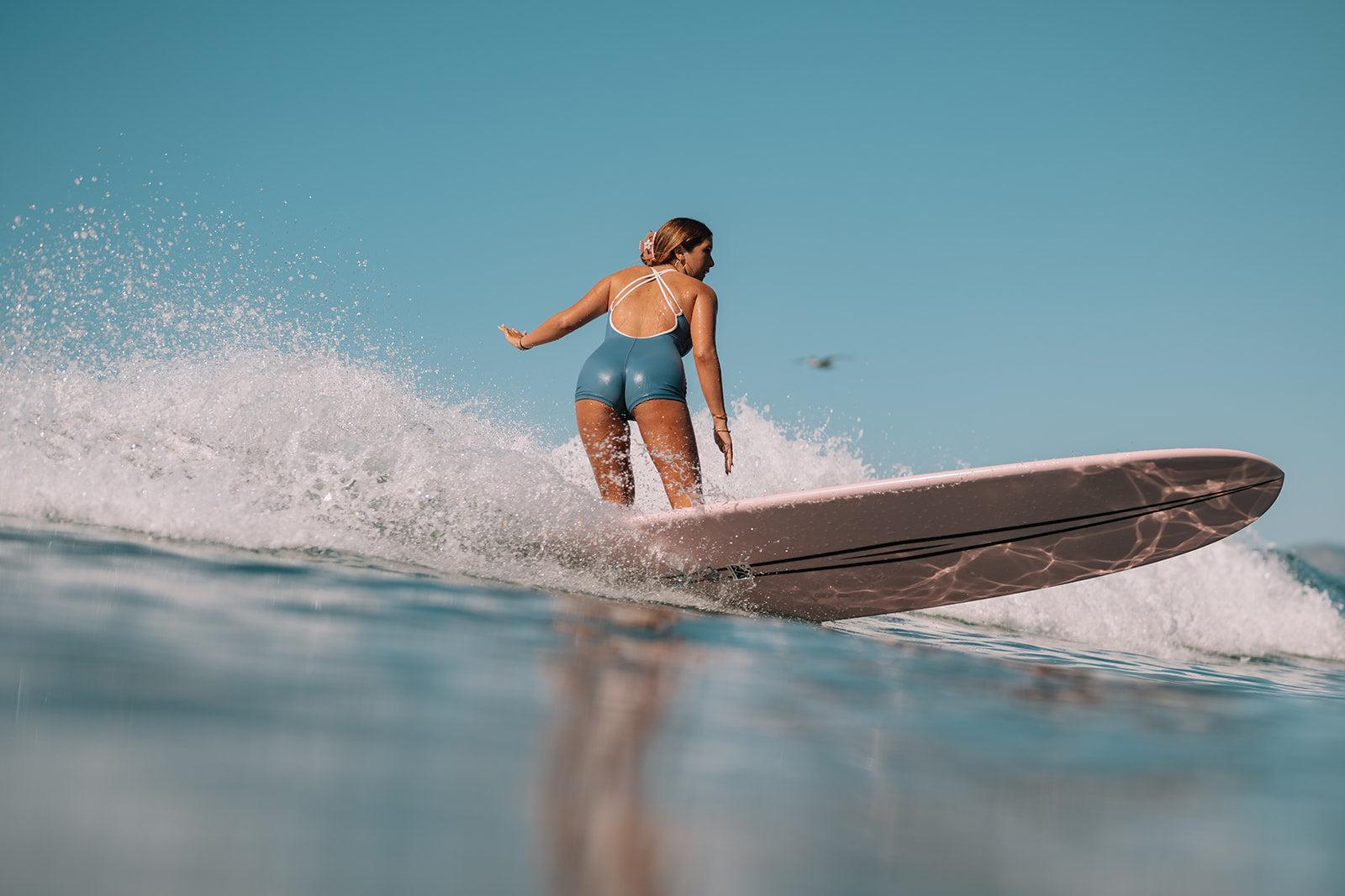 Person surfing on a wave with clear blue sky