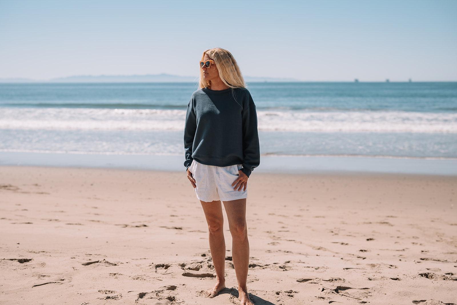 Woman standing on a beach with ocean waves in the background