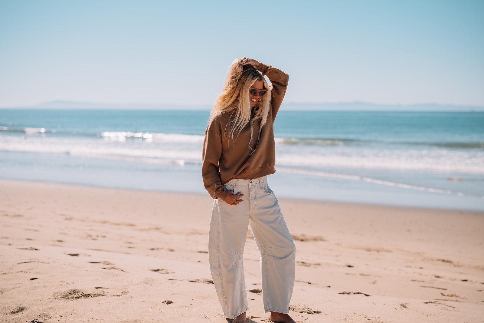 Woman wearing brown crew shirt on the beach.
